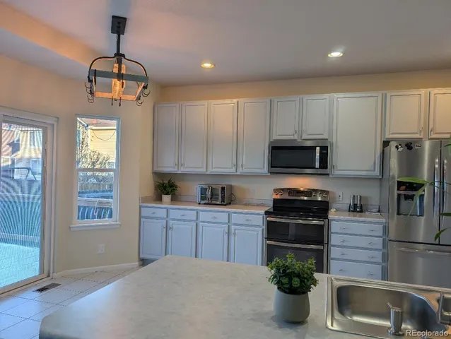 a kitchen with cabinets a window and stainless steel appliances