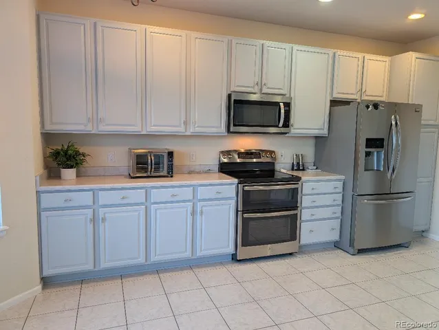 a kitchen with white cabinets and stainless steel appliances