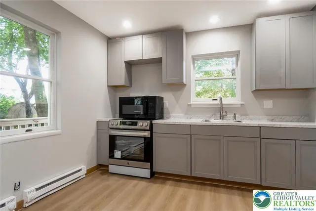 a kitchen with granite countertop a stove a sink and a microwave