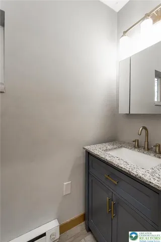a bathroom with a granite countertop sink and vanity