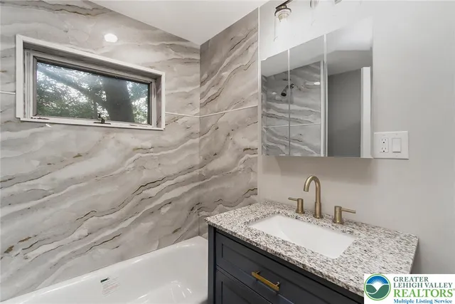 a bathroom with a granite countertop sink and a mirror