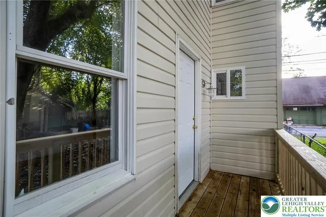 a view of a balcony with wooden floor and iron gate