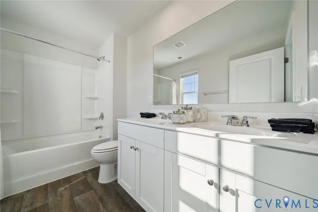 a bathroom with a sink toilet a mirror and shower