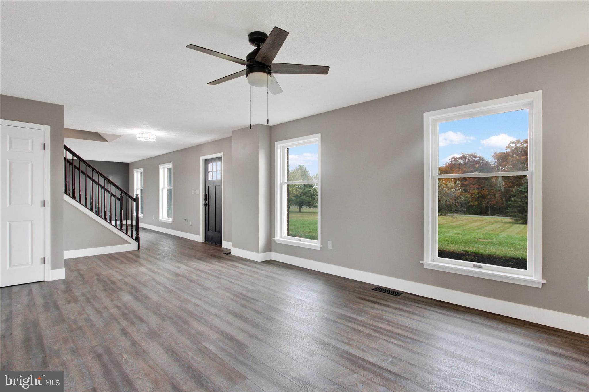 30 Harney Road Littlestown, PA 17340 - Photo 15 of 45 a view of a livingroom with wooden floor a ceiling fan and windows