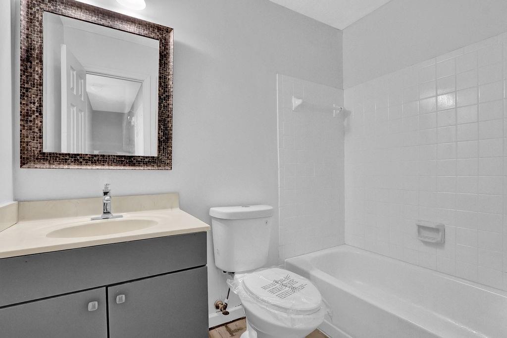 5409 Biffle Downs Road Stone Mountain, GA 30088 - Photo 16 of 27 a bathroom with a toilet a sink a mirror and a bathtub