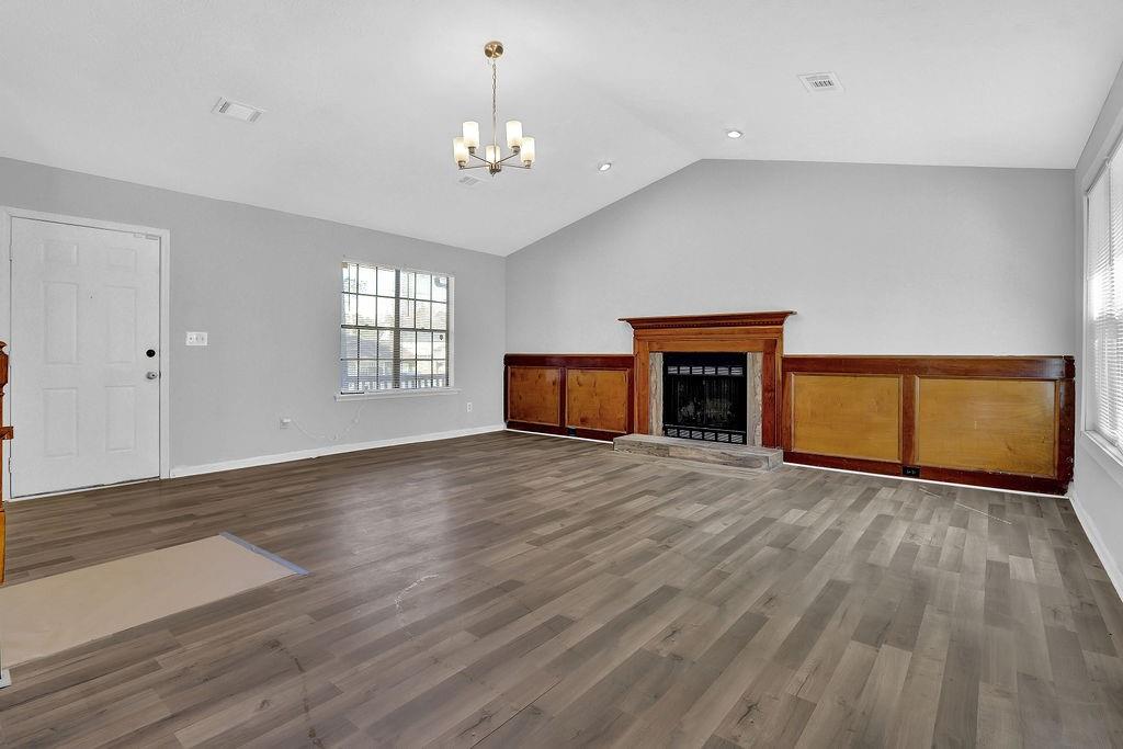 5409 Biffle Downs Road Stone Mountain, GA 30088 - Photo 6 of 27 an empty room with wooden floor fireplace and window