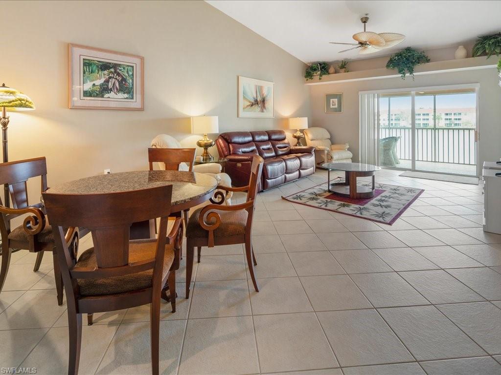 2810 Cypress Trace Circle, Unit 2127 Naples, FL 34119 - Photo 11 of 28 a living room with furniture a flat screen tv and a dining table