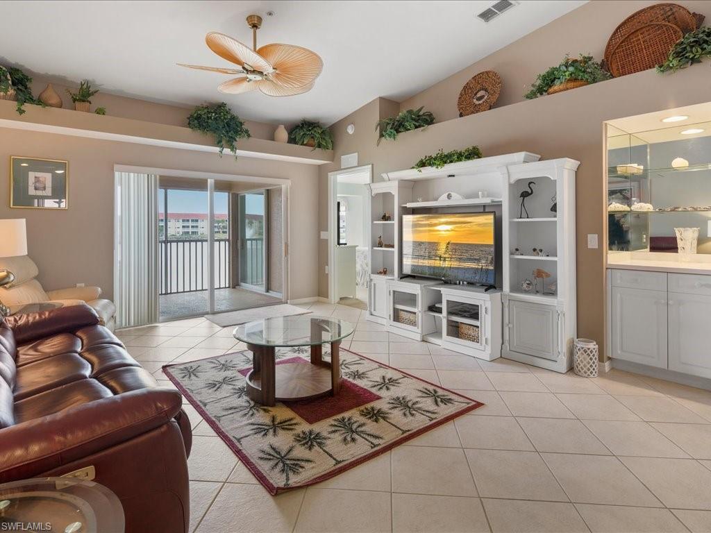 2810 Cypress Trace Circle, Unit 2127 Naples, FL 34119 - Photo 13 of 28 a living room with furniture and a flat screen tv