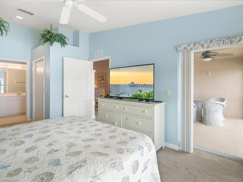 2810 Cypress Trace Circle, Unit 2127 Naples, FL 34119 - Photo 16 of 28 a bedroom with a bed and a flat screen television