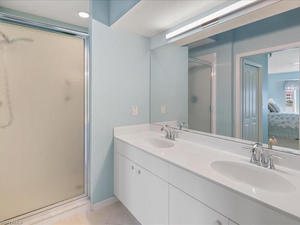 2810 Cypress Trace Circle, Unit 2127 Naples, FL 34119 - Photo 18 of 28 a bathroom with a double vanity sink and a mirror