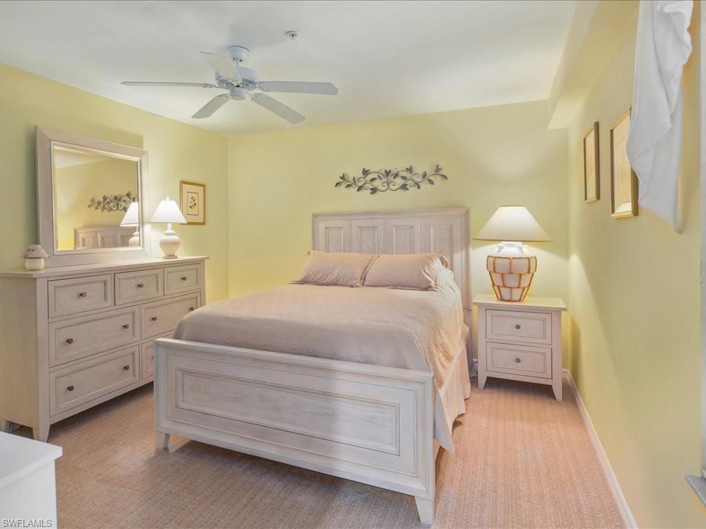 2810 Cypress Trace Circle, Unit 2127 Naples, FL 34119 - Photo 19 of 28 a bedroom with a bed and a night stand