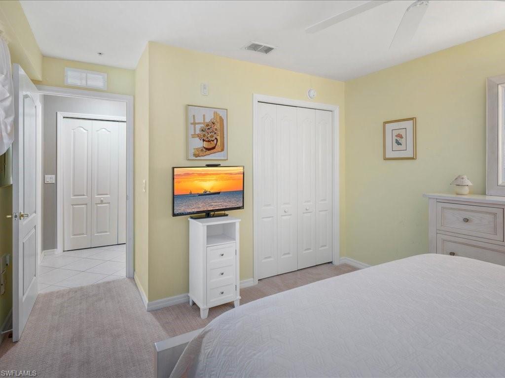 2810 Cypress Trace Circle, Unit 2127 Naples, FL 34119 - Photo 20 of 28 a bedroom with a bed and wooden floor