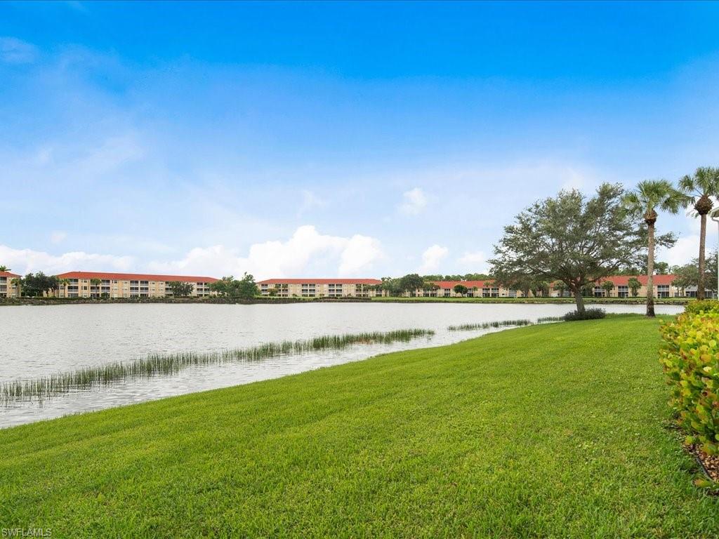 2810 Cypress Trace Circle, Unit 2127 Naples, FL 34119 - Photo 25 of 28 a view of a lake with houses in the back