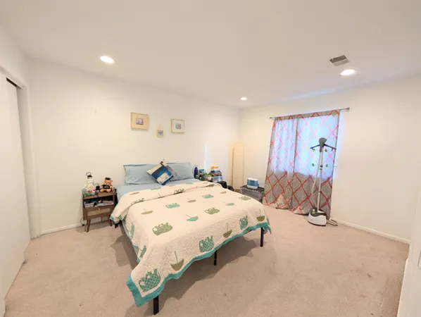 a bedroom with a bed and a painting on the wall