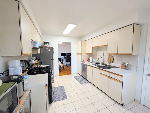 a kitchen with stainless steel appliances kitchen island granite countertop a refrigerator and a stove top oven