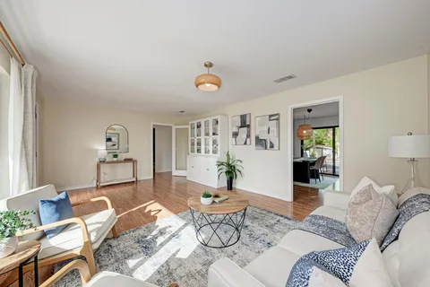 a living room with furniture and wooden floor