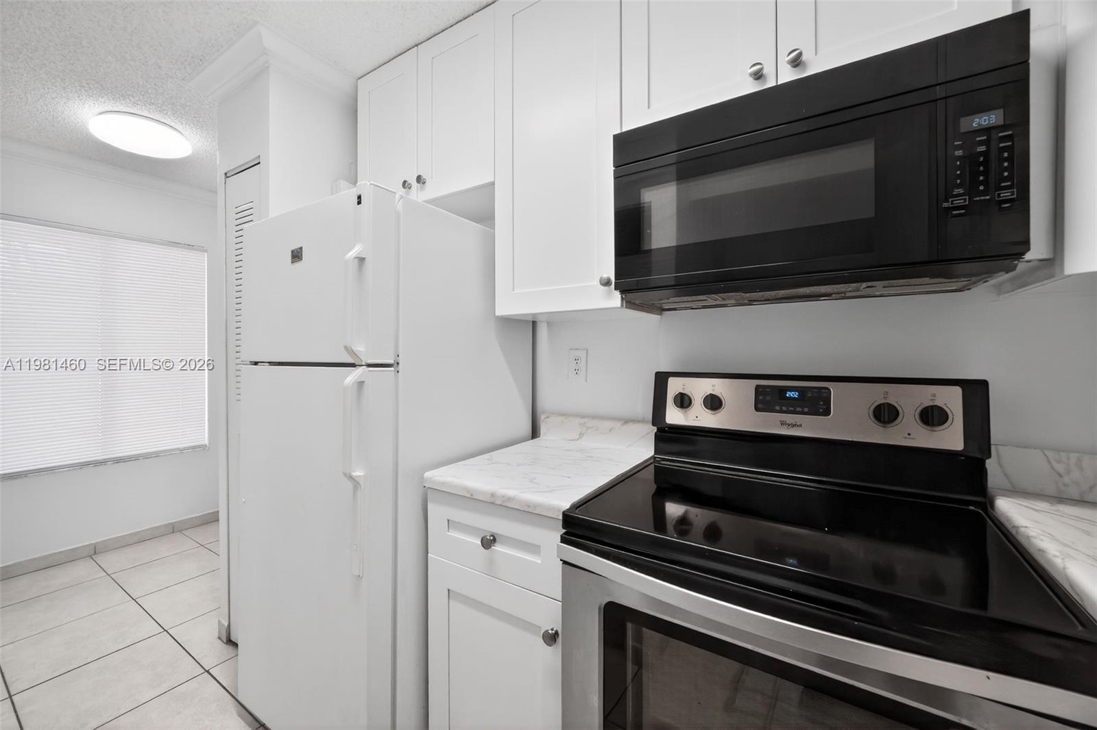 9436 Southwest 140th Court, Unit 9436 Miami, FL 33186 - Photo 11 of 40 a kitchen with a stove and a microwave