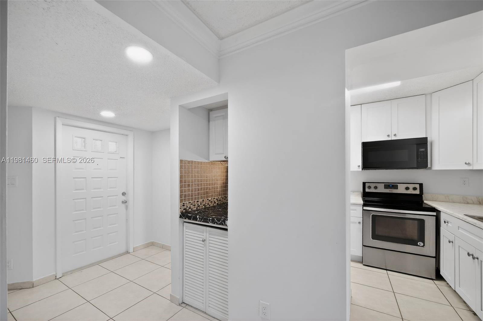 9436 Southwest 140th Court, Unit 9436 Miami, FL 33186 - Photo 13 of 40 a kitchen with white cabinets and stainless steel appliances