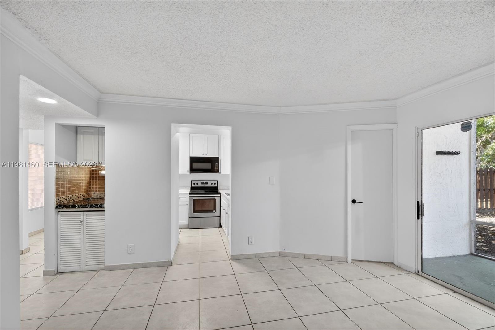 9436 Southwest 140th Court, Unit 9436 Miami, FL 33186 - Photo 14 of 40 a view of a livingroom with an empty space and a kitchen