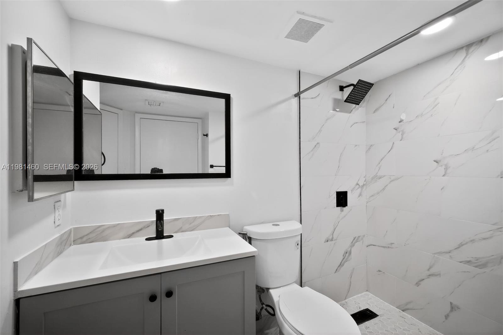 9436 Southwest 140th Court, Unit 9436 Miami, FL 33186 - Photo 24 of 40 a bathroom with a toilet sink a mirror a vanity and shower
