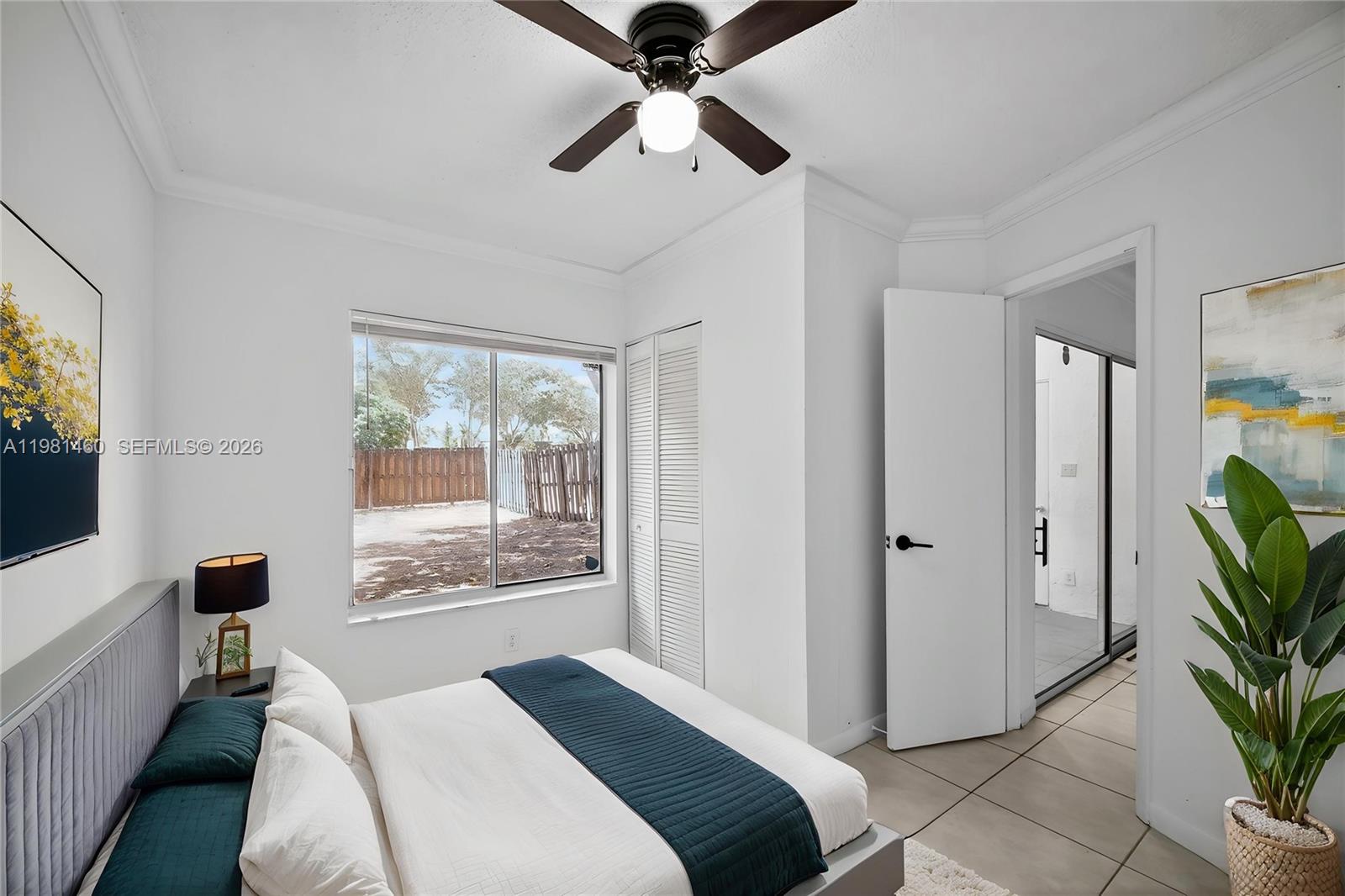 9436 Southwest 140th Court, Unit 9436 Miami, FL 33186 - Photo 25 of 40 a bedroom with a bed and a chandelier