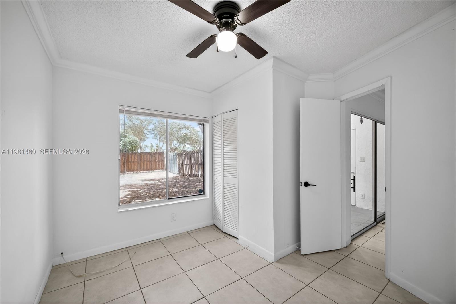 9436 Southwest 140th Court, Unit 9436 Miami, FL 33186 - Photo 26 of 40 a view of an empty room with window chandelier fan and kitchen view