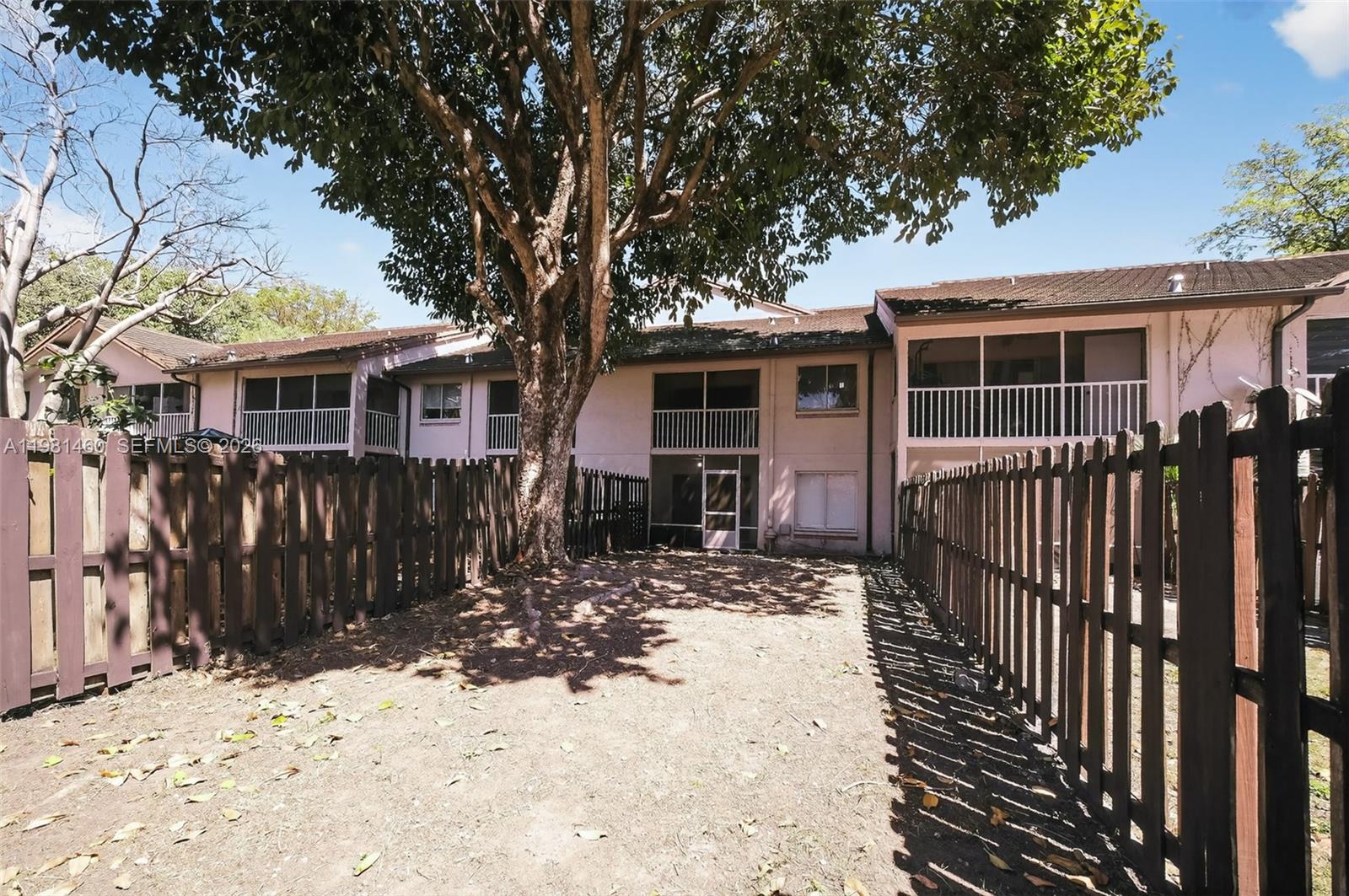 9436 Southwest 140th Court, Unit 9436 Miami, FL 33186 - Photo 33 of 40 a view of a house with wooden fence next to a house