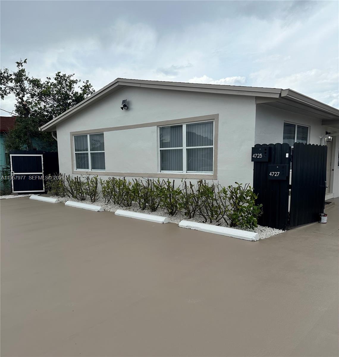4727 Northwest 4th Street, Unit 4727 Miami, FL 33126 - Photo 14 of 14 a front view of house with yard and trees around