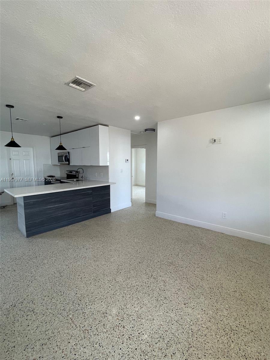 4727 Northwest 4th Street, Unit 4727 Miami, FL 33126 - Photo 7 of 14 a kitchen with kitchen island a sink a stove and a refrigerator