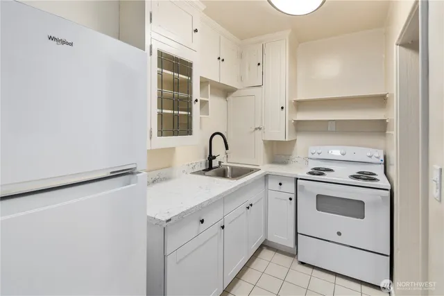 a kitchen with white cabinets appliances and sink