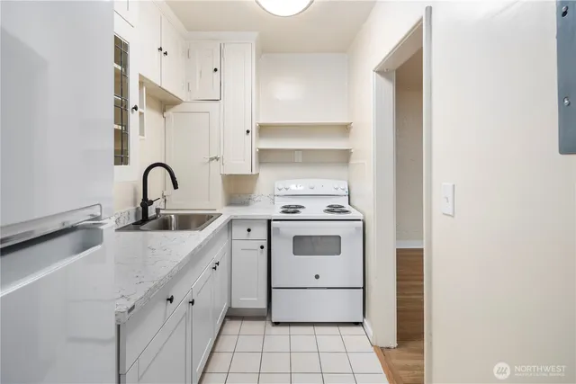 a kitchen with white cabinets and white appliances