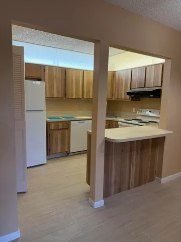 a kitchen with kitchen island granite countertop a stove and a refrigerator