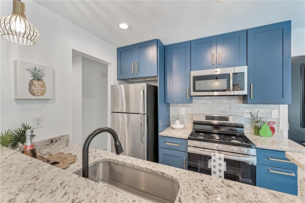 2867 Joyce Avenue Decatur, GA 30032 - Photo 1 of 1 a kitchen with stainless steel appliances a stove refrigerator a microwave a sink and cabinets