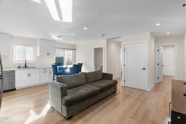 a living room with furniture and kitchen view