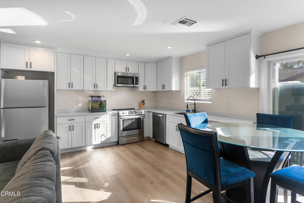 2549 Young Avenue, Unit B Thousand Oaks, CA 91360 - Photo 5 of 14 a kitchen with a refrigerator a stove a sink a dining table and chairs