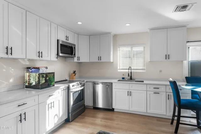 a kitchen with a sink stove and white cabinets