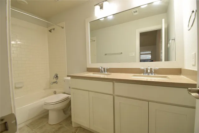 a bathroom with a granite countertop toilet a sink and a bathtub