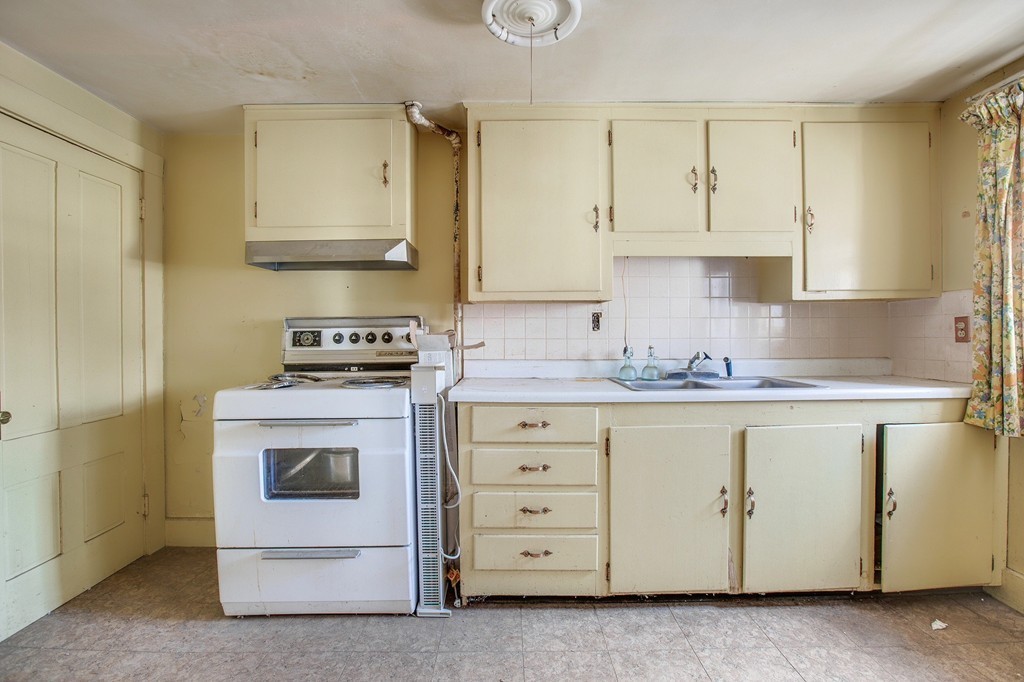 218 West Street Reading, MA 01867 - Photo 13 of 22 a kitchen with granite countertop white cabinets and white appliances