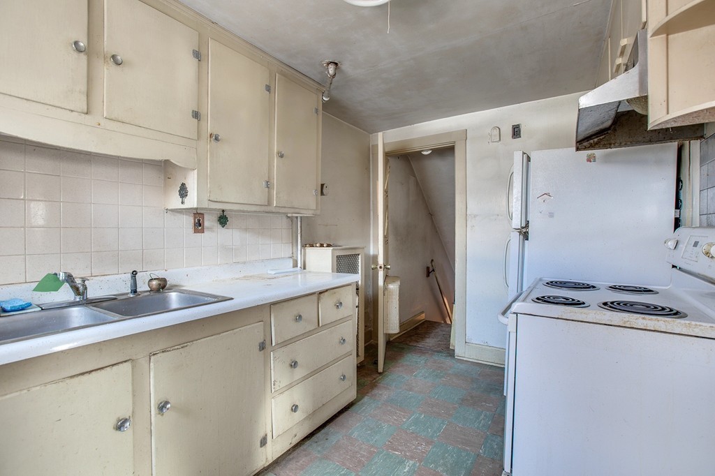 218 West Street Reading, MA 01867 - Photo 7 of 22 a kitchen with cabinets appliances a sink and a counter top