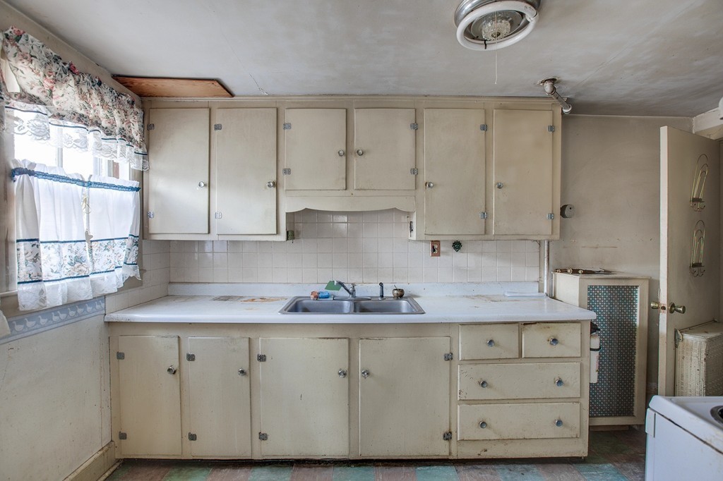 218 West Street Reading, MA 01867 - Photo 8 of 22 a kitchen with granite countertop white cabinets and stainless steel appliances