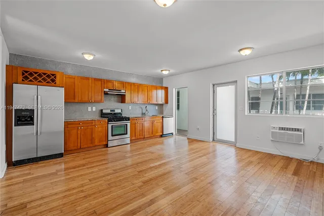 a kitchen with stainless steel appliances granite countertop a refrigerator and a stove top oven