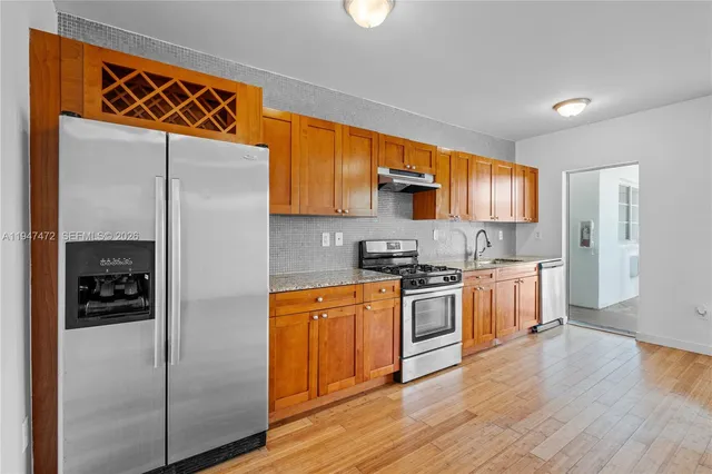 a kitchen with stainless steel appliances granite countertop a refrigerator and a stove top oven