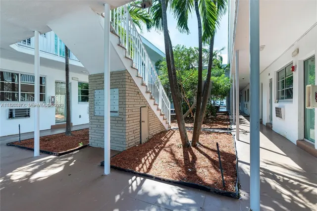 a view of backyard with swimming pool and furniture