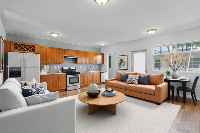 a living room with furniture and a view of kitchen