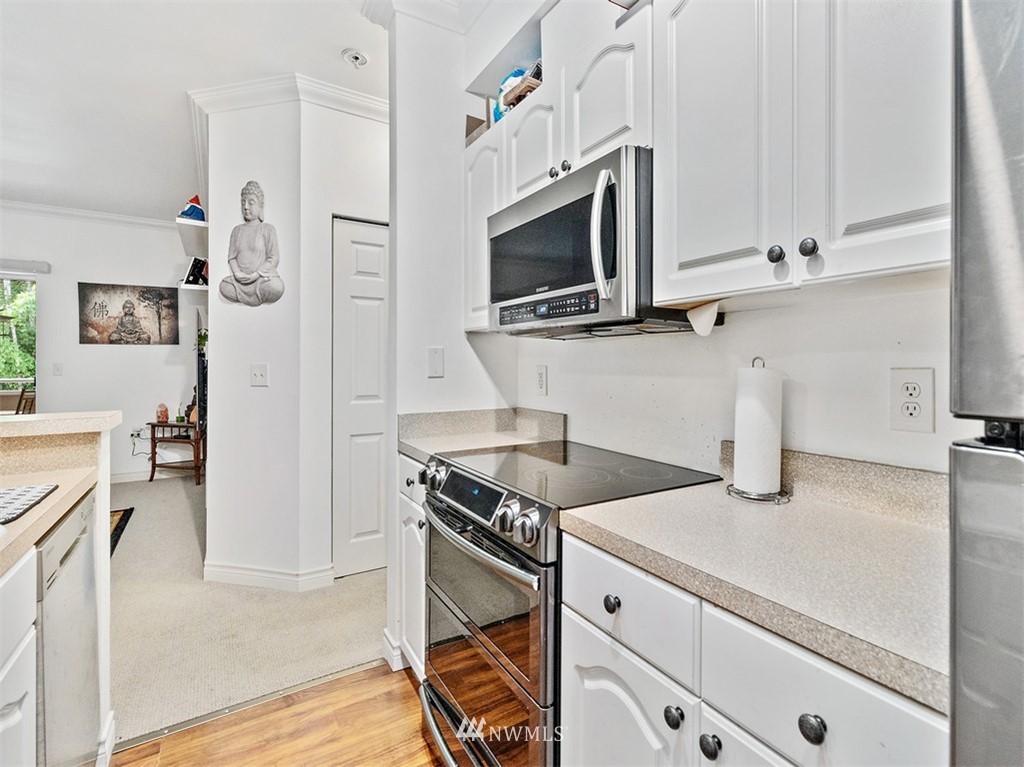 801 Rainier Avenue North, Unit G234 Renton, WA 98057 - Photo 8 of 19 a kitchen with stainless steel appliances granite countertop a stove and a microwave