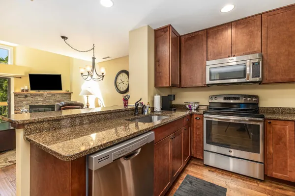 a kitchen with granite countertop a sink and a large mirror