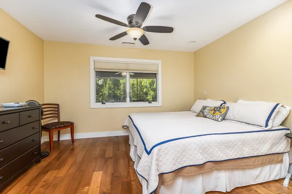 a bedroom with a large bed and wooden floor