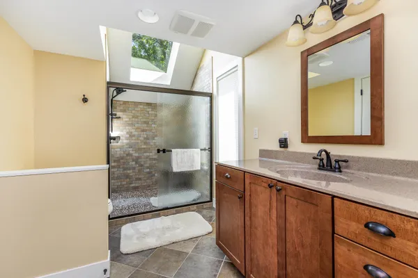 a en suite bathroom with a sink a mirror and a shower