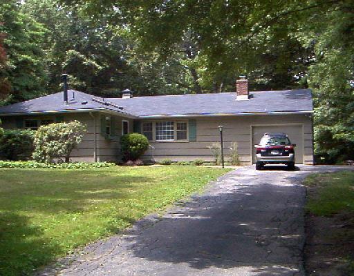 54 Bayberry Hill Road Ridgefield, CT 06877 - Photo 1 of 1 a front view of a house with a garden and trees