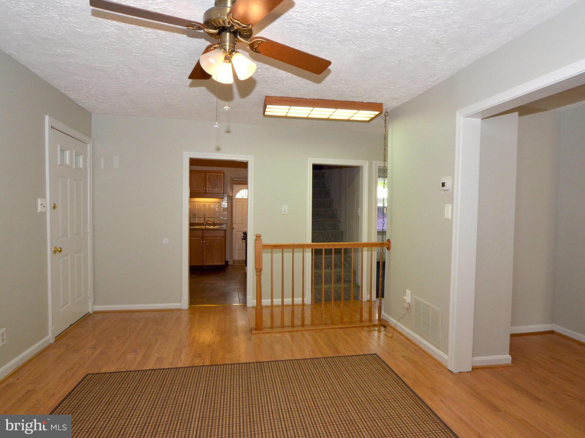 6720 Larkspur Road Morningside, MD 20746 - Photo 5 of 29 a view of a hallway with wooden floor and a chandelier